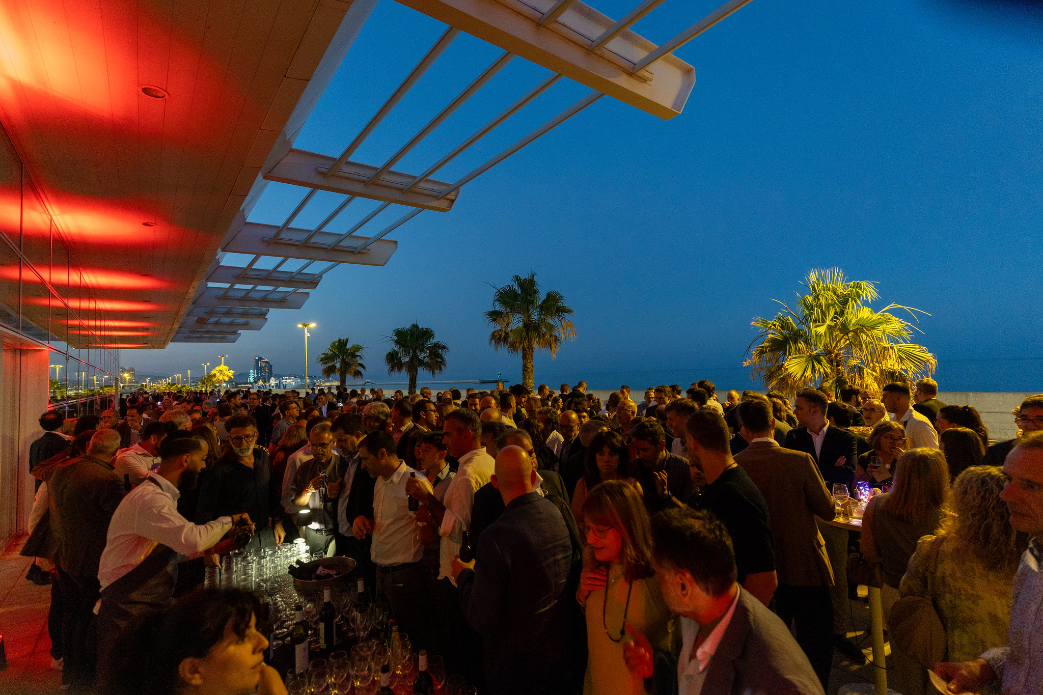 Assistents a l’esdeveniment durant el còctel de networking davant del mar.